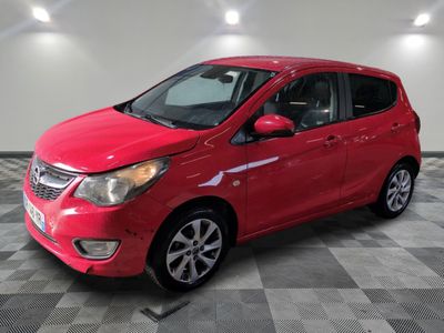 a red car is parked in a room with a checkered floor
