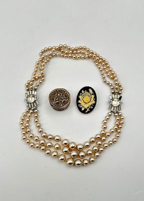un gros plan sur un collier et une pièce de monnaie posés sur une table