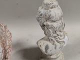 two statues of a man and a woman sitting on a table