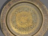 an image of a gold plate with designs on it