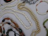 many necklaces and bracelets laid out on a table