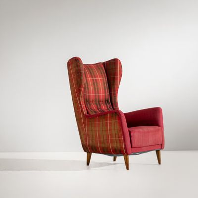 a red chair with a plaid cushion and wooden legs in a white room