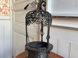 a black birdcage sitting on a wooden table in a room