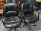 trois fauteuils de bureau en cuir noir dans une pièce, avec une commode en arrière-plan