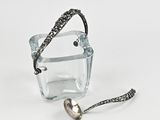 un récipient en verre contenant une cuillère et une autre cuillère à l'intérieur