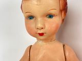 a small doll that is sitting on a white surface