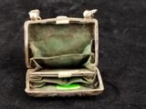 an open suitcase with a green cloth inside on a black surface