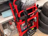 a red wheel chair sitting next to a pile of tires