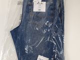 two pairs of blue jeans are wrapped in plastic on a white surface
