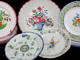 four plates with different designs on them on a black surface