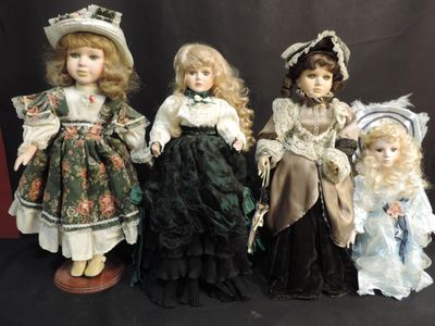 four dolls of different sizes and colors are lined up on a black background