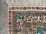 a close up of a rug with fringes on a concrete floor