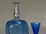 a blue glass bottle and a yellow glass goblet