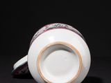 a white cup sitting on a table with a black background
