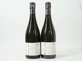 deux bouteilles de vin posées l'une à côté de l'autre sur une surface blanche