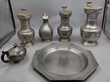 de nombreux vases en argent et un plateau en argent posés sur une table