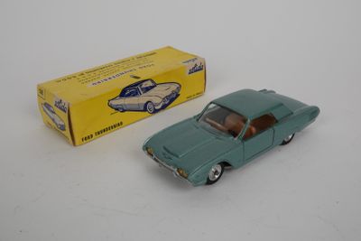 une petite voiture verte posée à côté d'une boîte sur une surface blanche