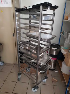 a metal rack with pans on it in a kitchen