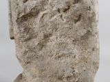 a close up of a stone statue of a person on a white surface