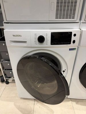 deux lave-linge et un sèche-linge empilés les uns sur les autres dans un magasin