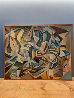 une photo d'un tableau posé sur une table, à côté d'un vase
