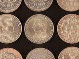 six different coins of different countries are shown on a black surface