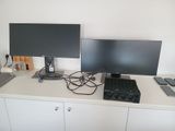 deux écrans et un ordinateur portable posés sur un bureau blanc