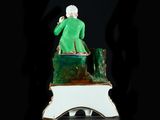 a figurine of a man sitting on top of a tree stump