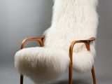 an image of a white sheepskin chair with a wooden frame