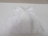 a white dress with a bow on it sitting on a table