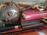 a pile of books on a table with a mask on top of it