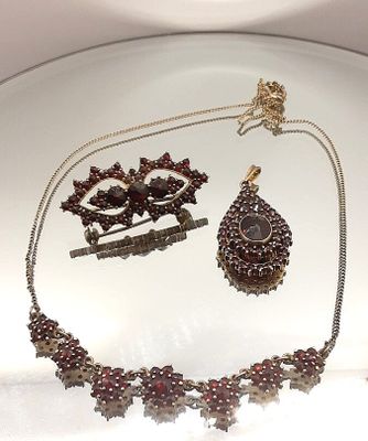 a plate with a necklace, bracelet, and earrings on it