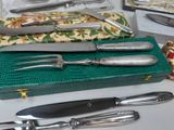 a green box with silverware on it and a knife, fork, and knife rest on a table