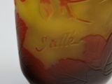 a glass vase with a yellow and red design on it
