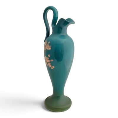 a green vase with a floral design on it