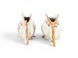 two small vases that are sitting on a white surface