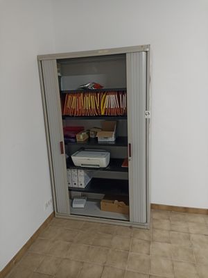 a small closet in the corner of a room with a printer on it