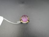 a close up of a ring with a pink stone on it