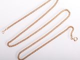 a close up of a gold chain on a white surface