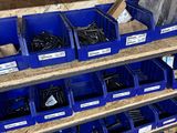 de nombreux bacs remplis de vis sur les étagères de l'atelier