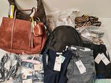 a lot of clothes and a purse on the floor