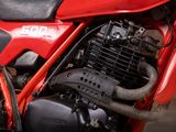 a close up of a red motorcycle parked in a garage