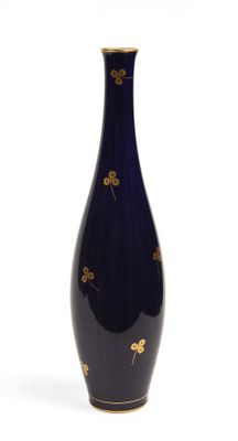 un vase bleu orné de fleurs dorées sur fond blanc