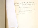 un livre ouvert sur lequel se trouve une feuille de papier