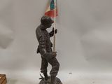 figurine of a soldier holding a flag on a wooden base