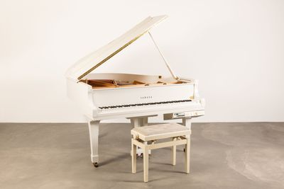 un piano blanc et un tabouret dans une pièce