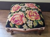 a small foot stool with a floral design on it