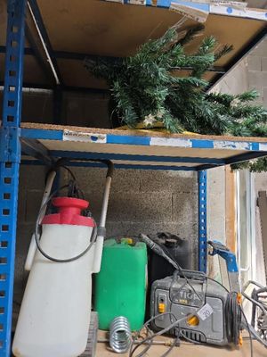 un petit sapin de Noël posé sur une étagère dans un garage