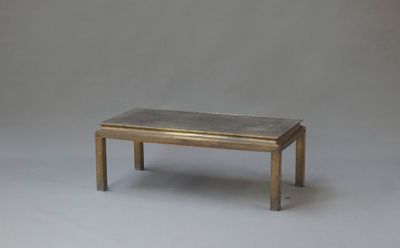une table basse avec un plateau en marbre sur fond gris