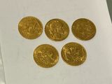 four gold coins sitting on top of a piece of paper